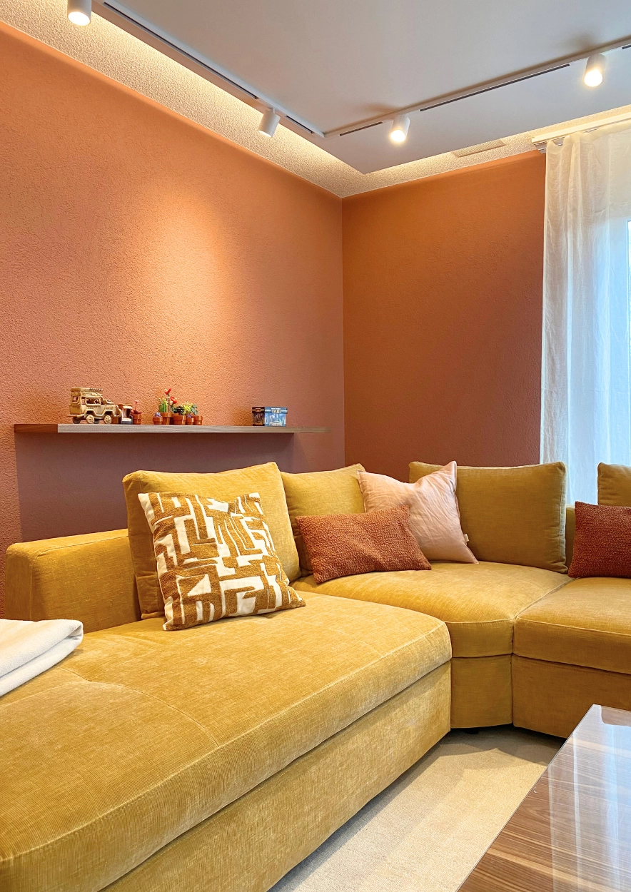Interior Design Projekt - Wohnzimmer in warmen Farbtönen - Zierkissen und Wandregal